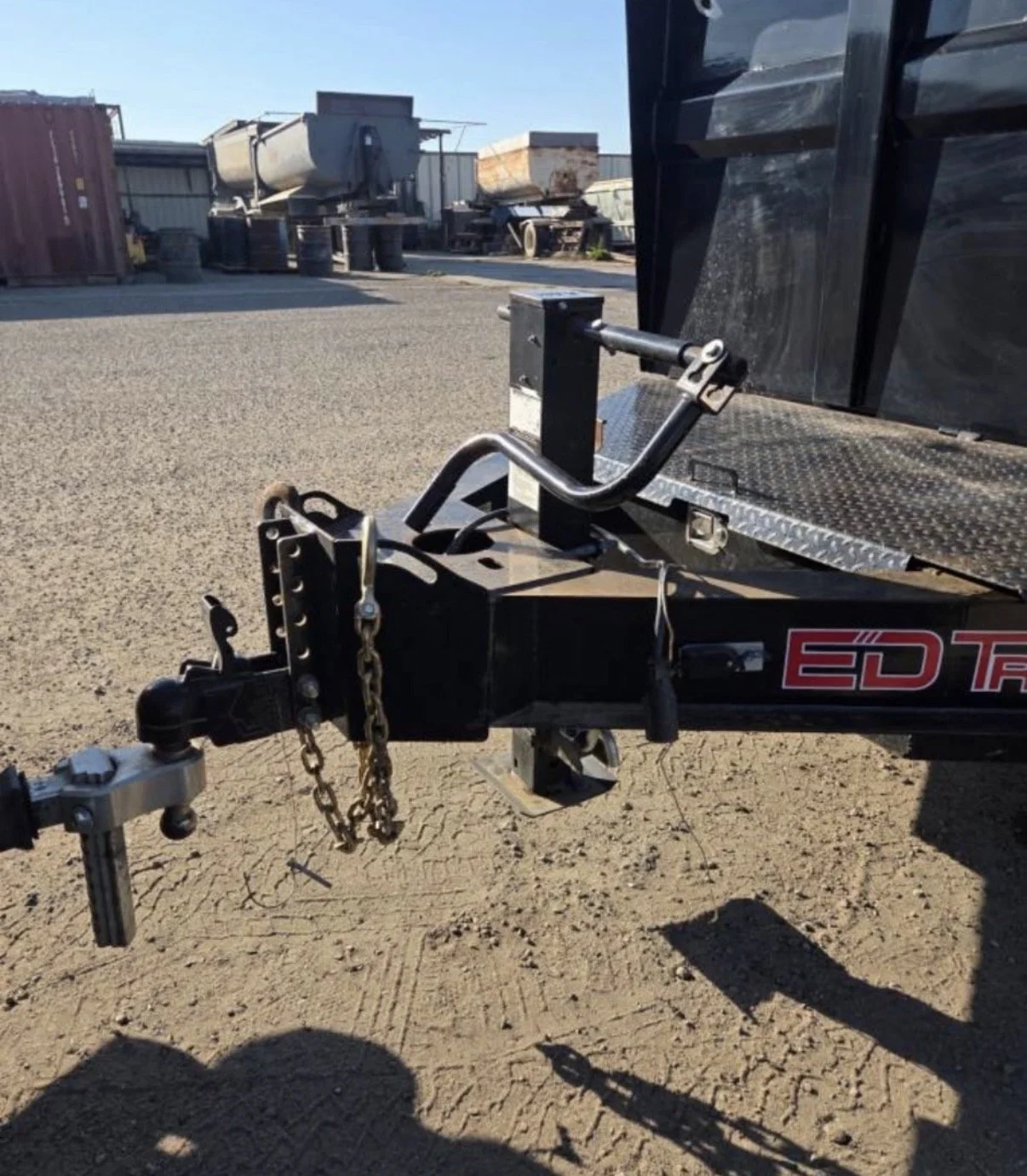 Close-up view of a trailer hitch with safety chains and a key attached
