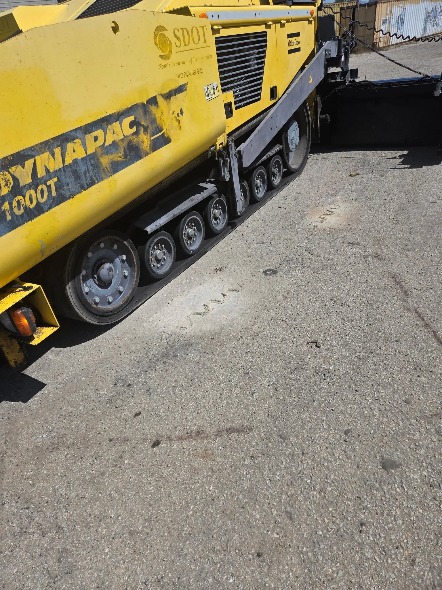2017 Dynapac F1000T asphalt paver, close-up showing rubber tracks and undercarriage.