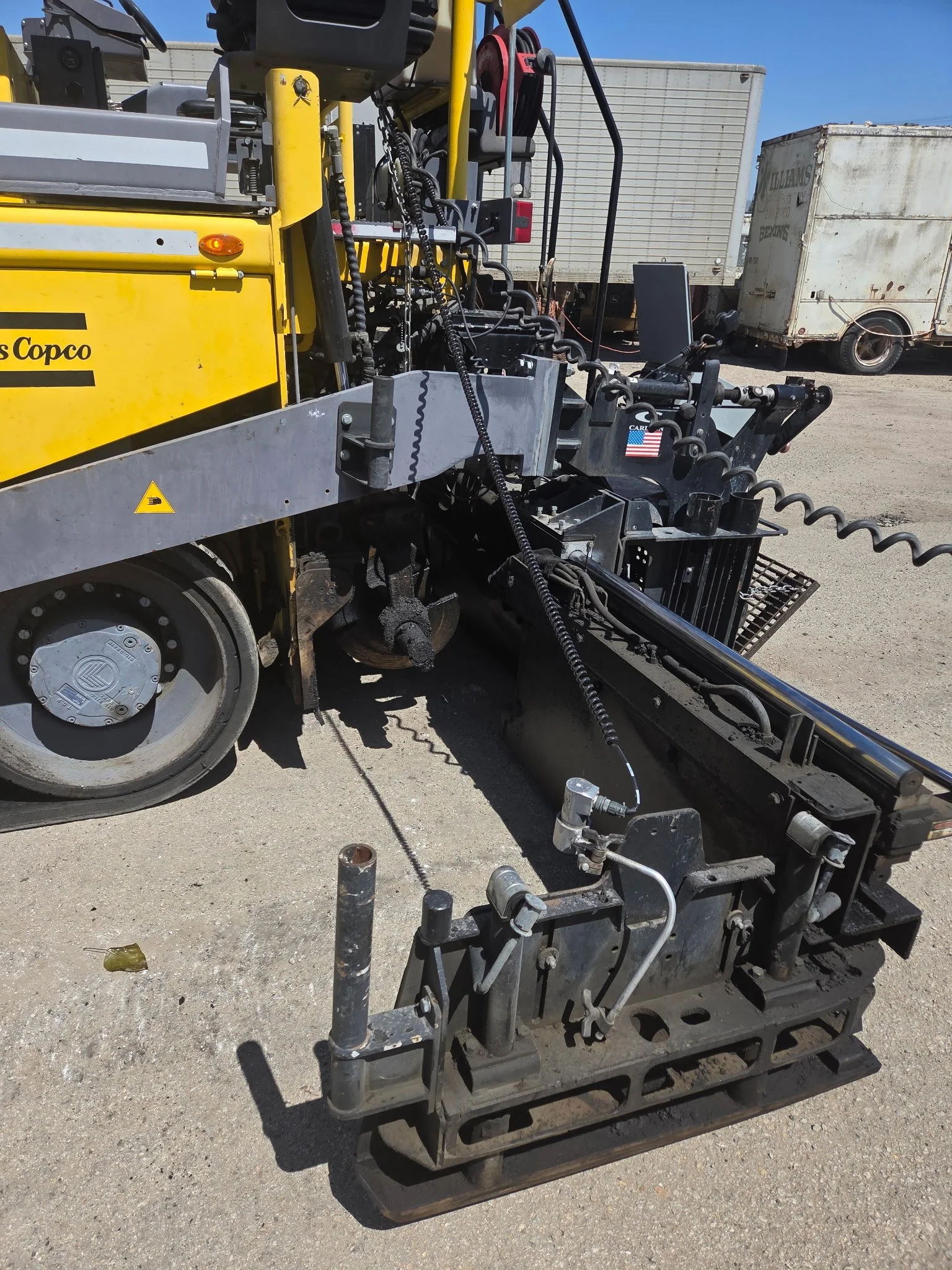 2017 Dynapac F1000T asphalt paver, rear view showing paving screed and mechanical components.