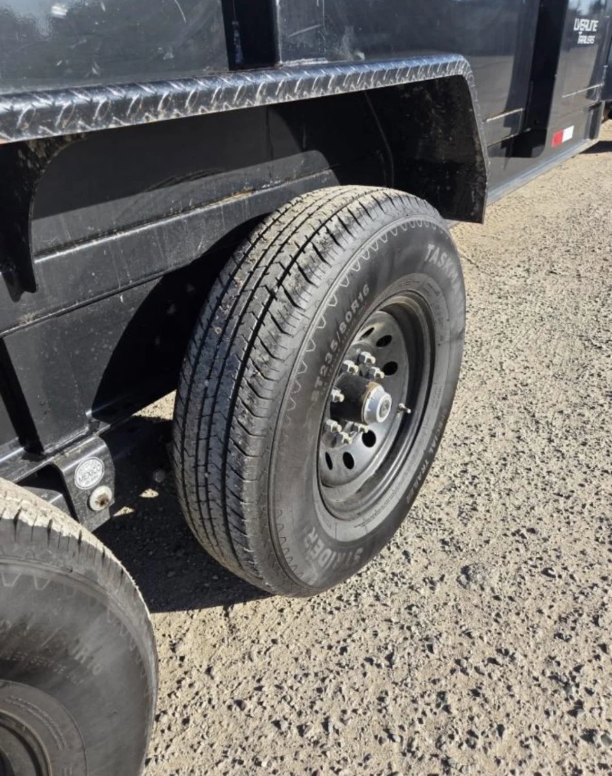 2026 ED dump trailer, close-up of tandem-axle tire and wheel.