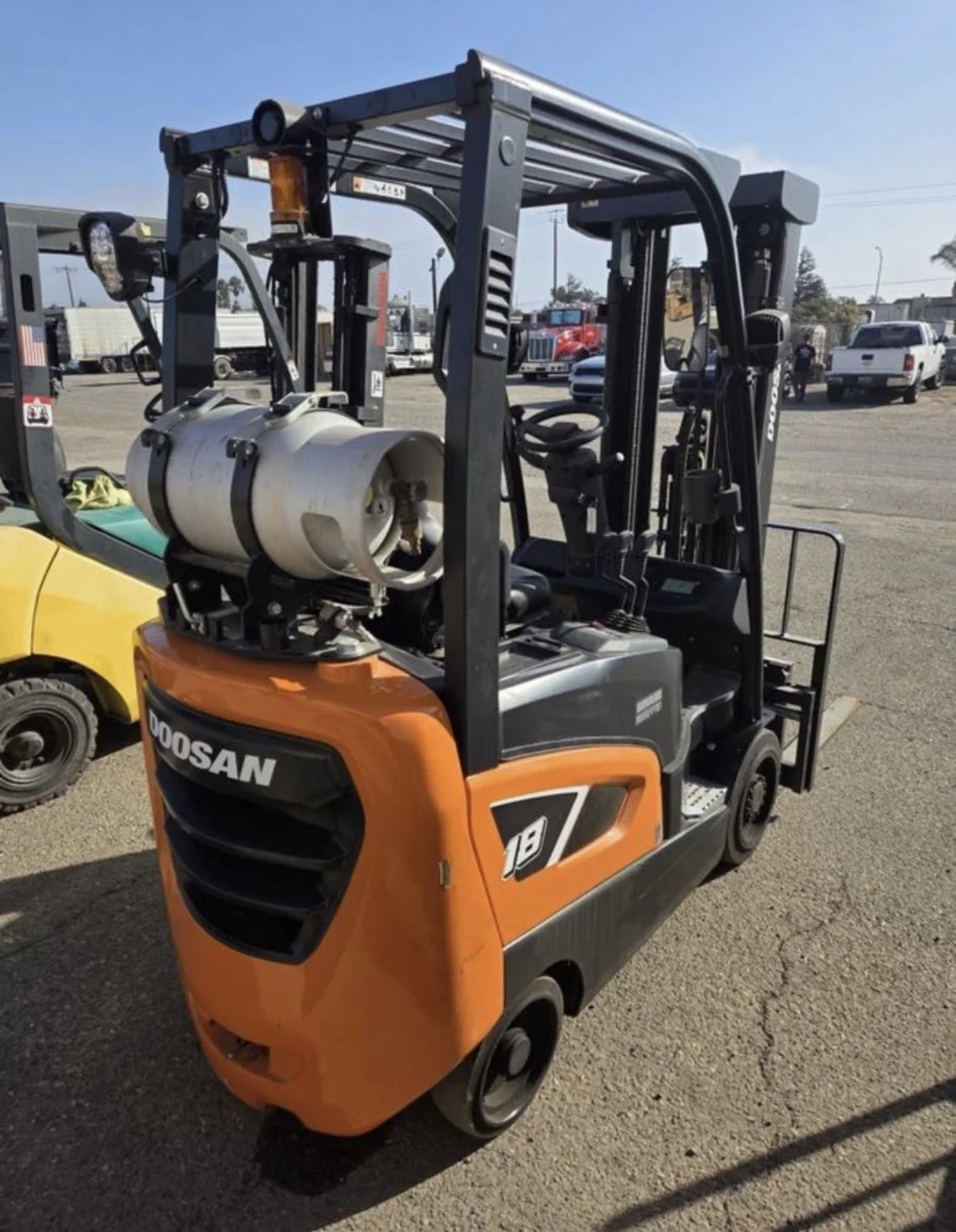2021 Doosan GC18S-9 forklift, rear-side view showing orange body and propane tank.