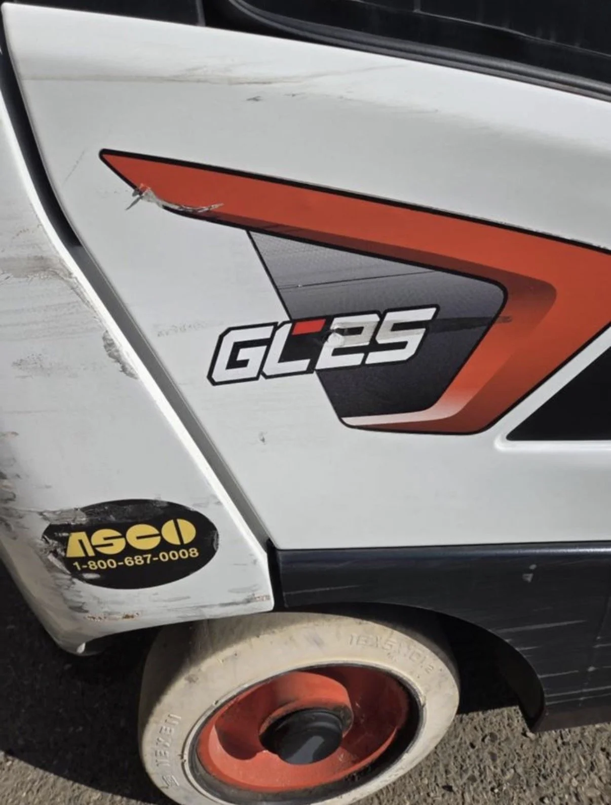 Close-up of a vehicle's side with a sticker showing the model 'GL25', a stylized red and black graphic, and an oval yellow and black sticker with the 'ISCO' logo and phone number.
