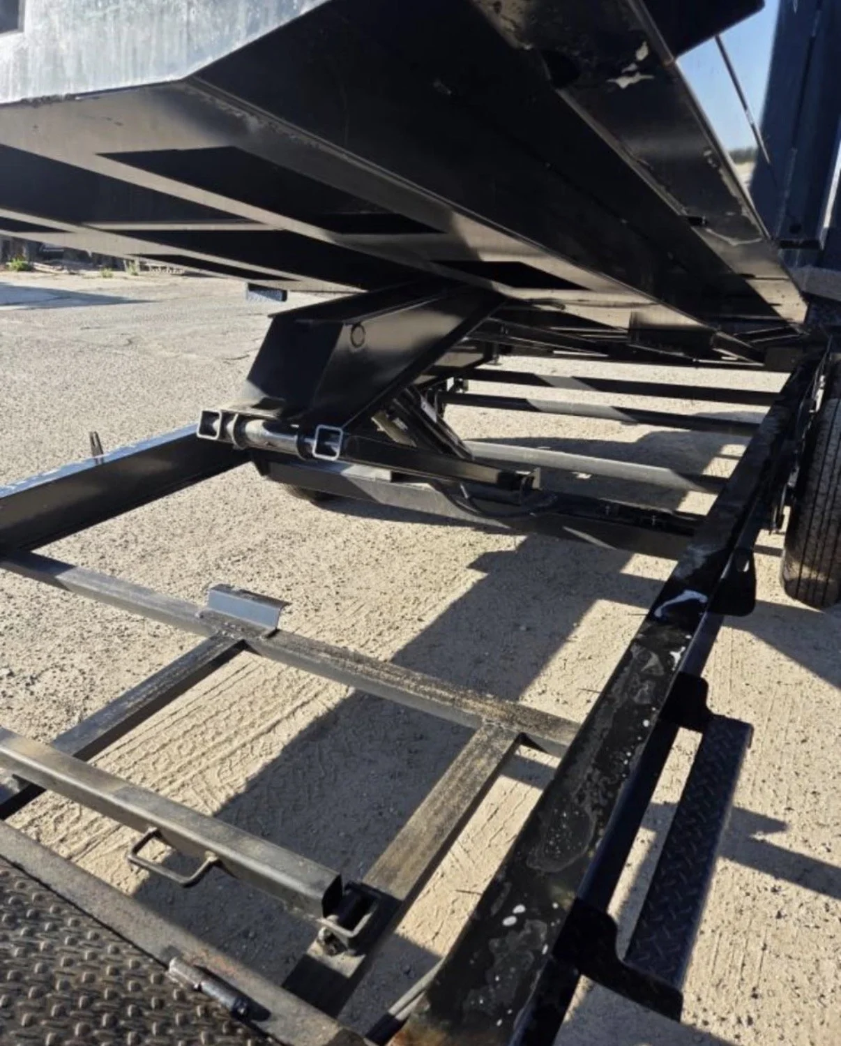 Close-up of a metal trailer with a hydraulic system and platform