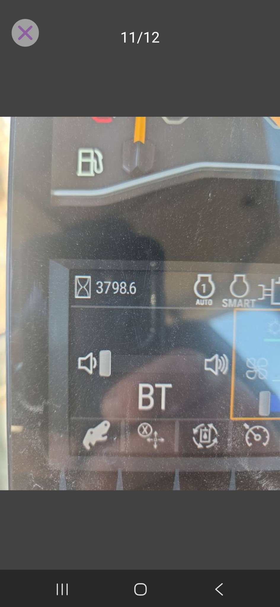 Close-up of a digital display panel showing a fuel meter, a distance of 3798.6 miles, and Bluetooth (BT) connection with other control icons.