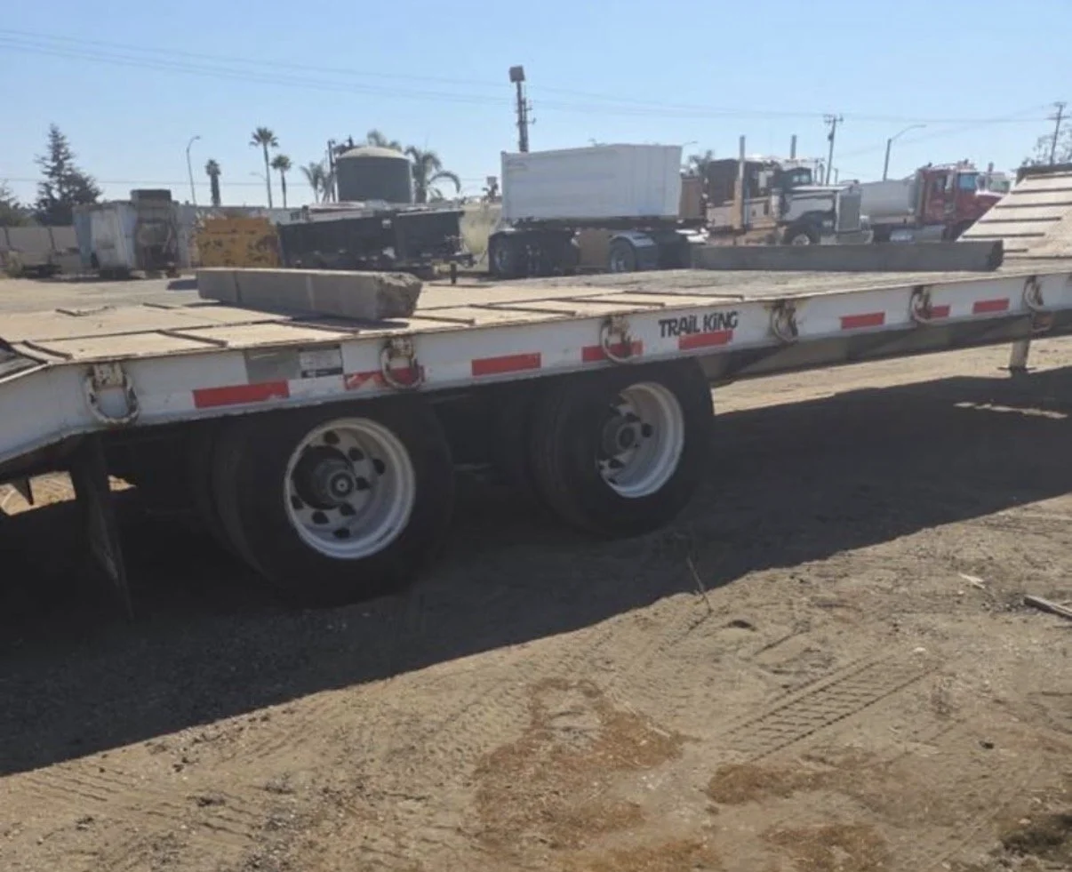 2008 Trail King equipment trailer, side view showing flatbed deck and tandem wheels.