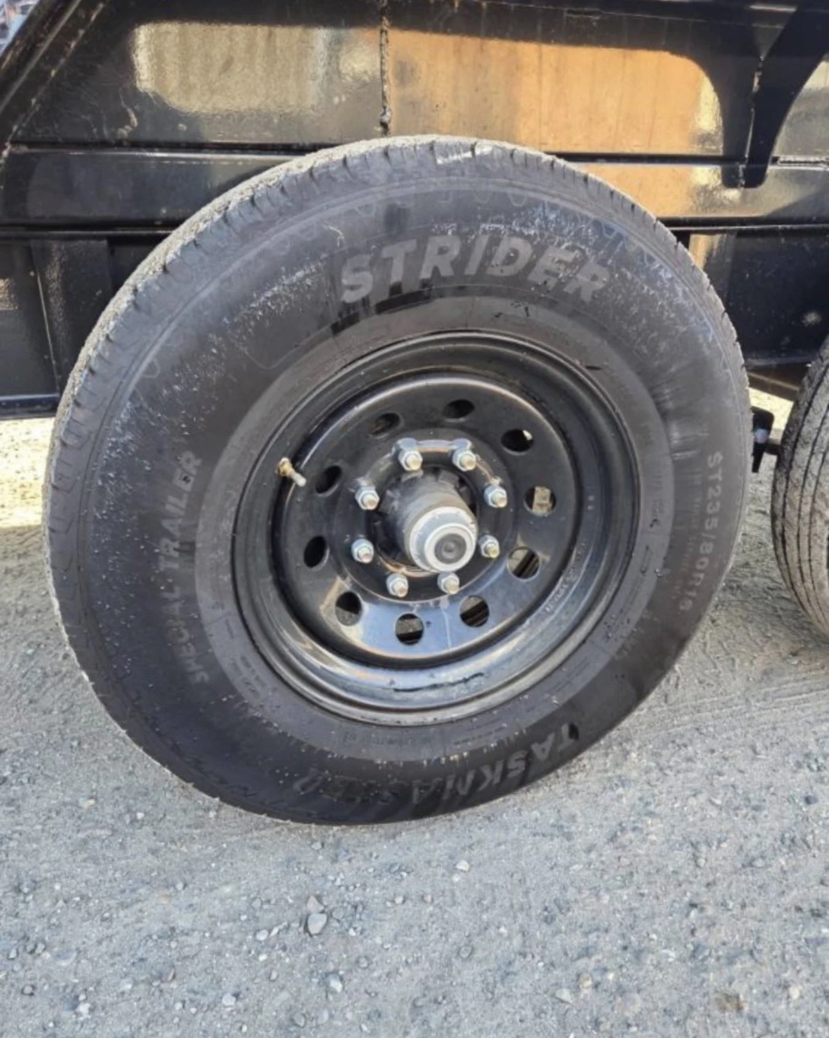 2026 ED dump trailer, close-up of black trailer tire and steel wheel.