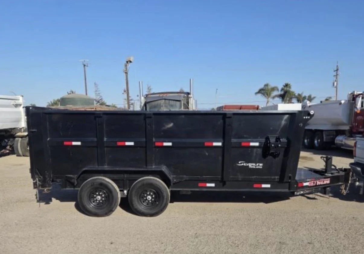 2026 ED dump trailer, side profile showing black steel body and tandem axles.