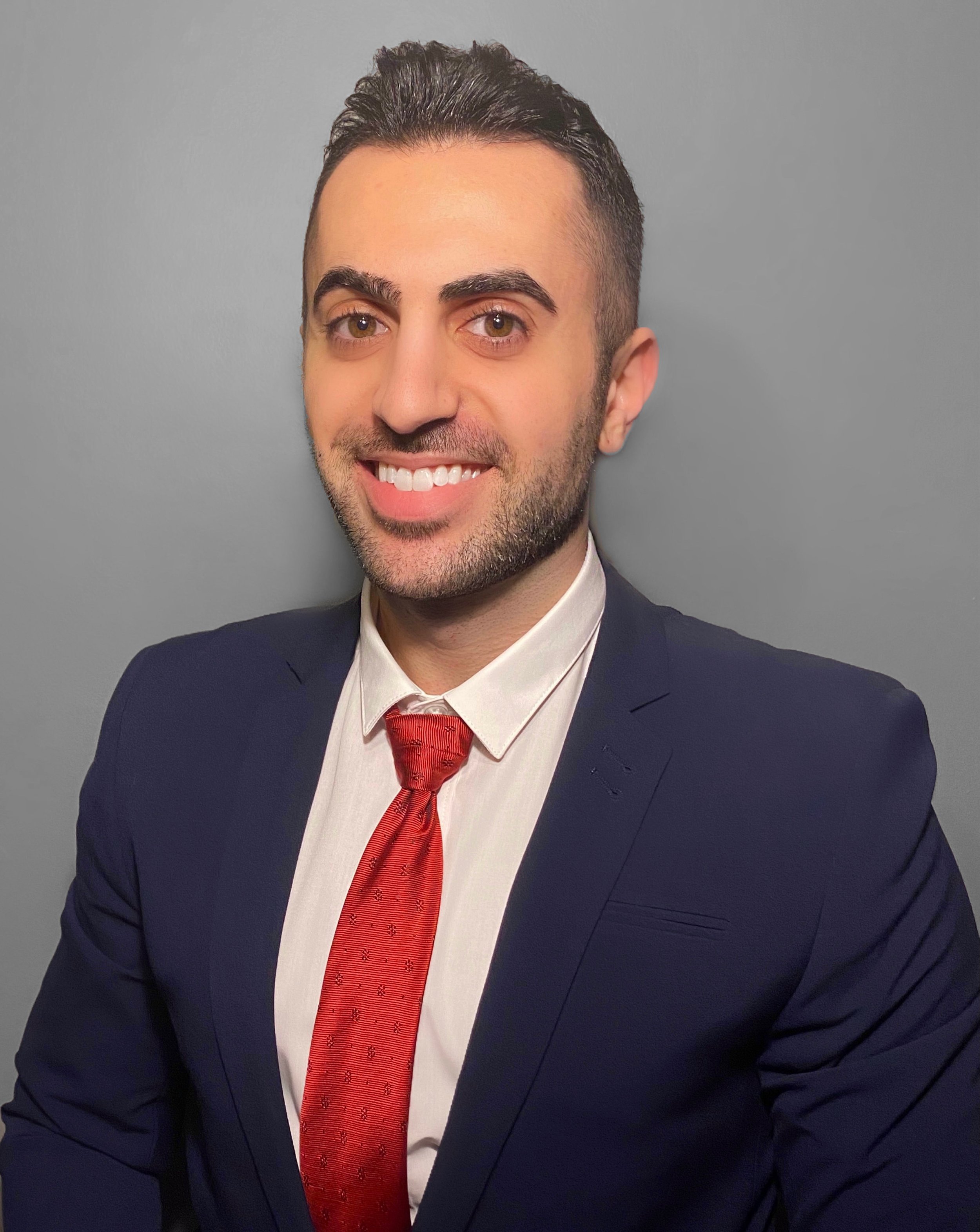 Professional headshot of a smiling man in a suit.