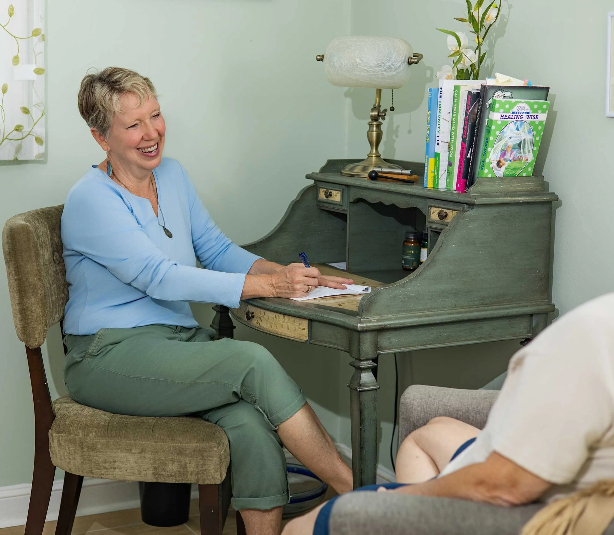 Lisa Garret, owner of Labyrinth Colon Hydrotherapy,  sitting at her office desk, during a client consultation.