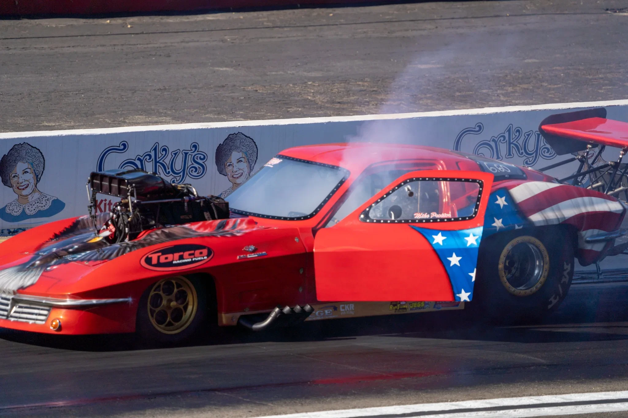 Red drag racing car accelerating along the strip. Photograph by Christopher Behymer.