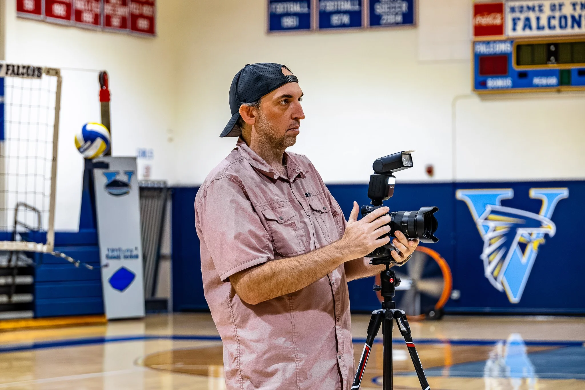 Christopher Behymer photographing in a gymnasium