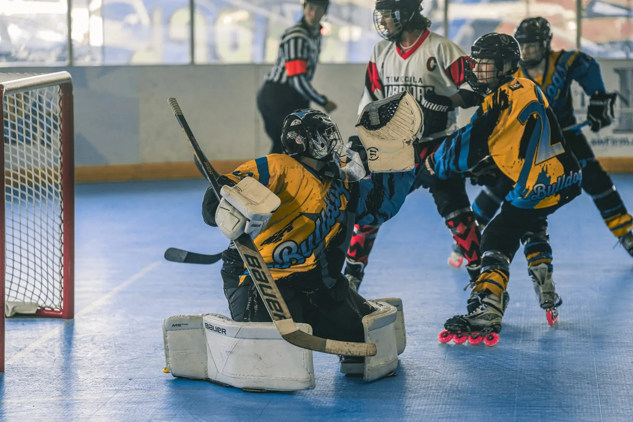 Roller-hockey players contest the puck near the goal. Photograph by Christopher Behymer.
