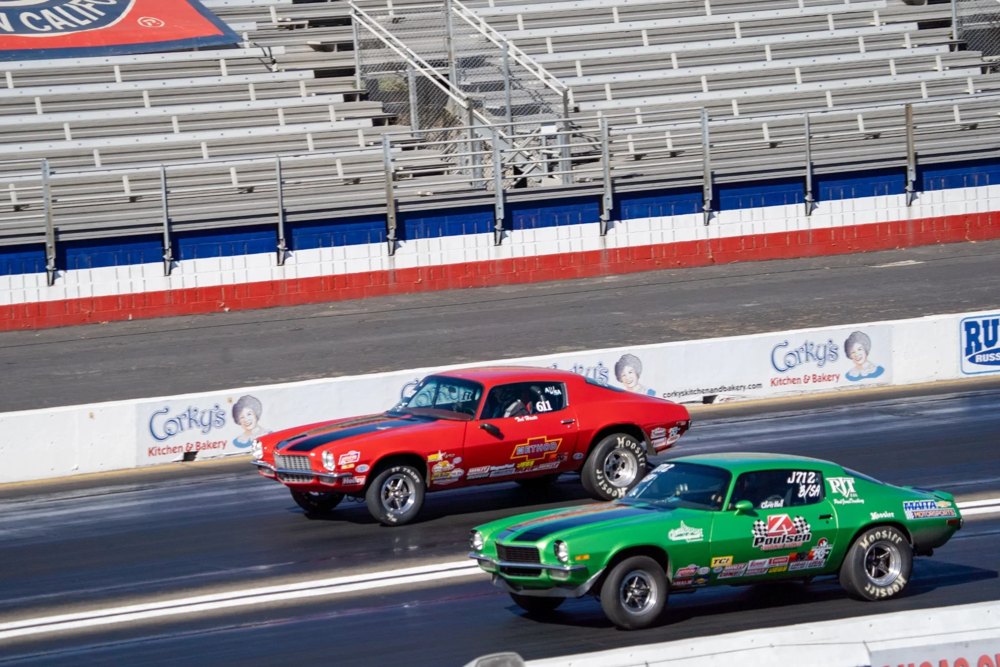 Red and green drag racing cars compete side by side. Photograph by Christopher Behymer.