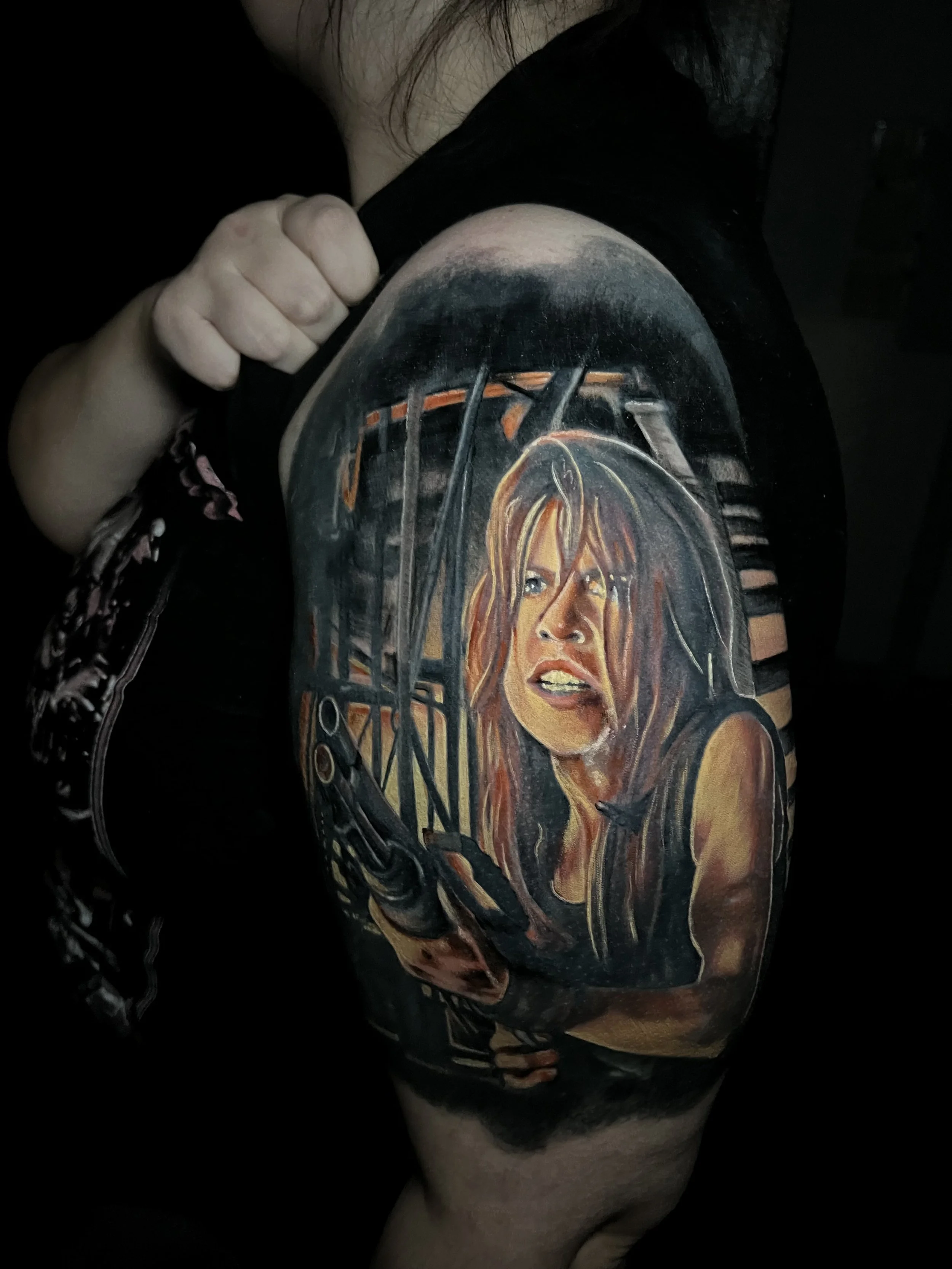 Close-up of a person's arm with a detailed tattoo drawing of a woman's face, long hair, and a smoky background.