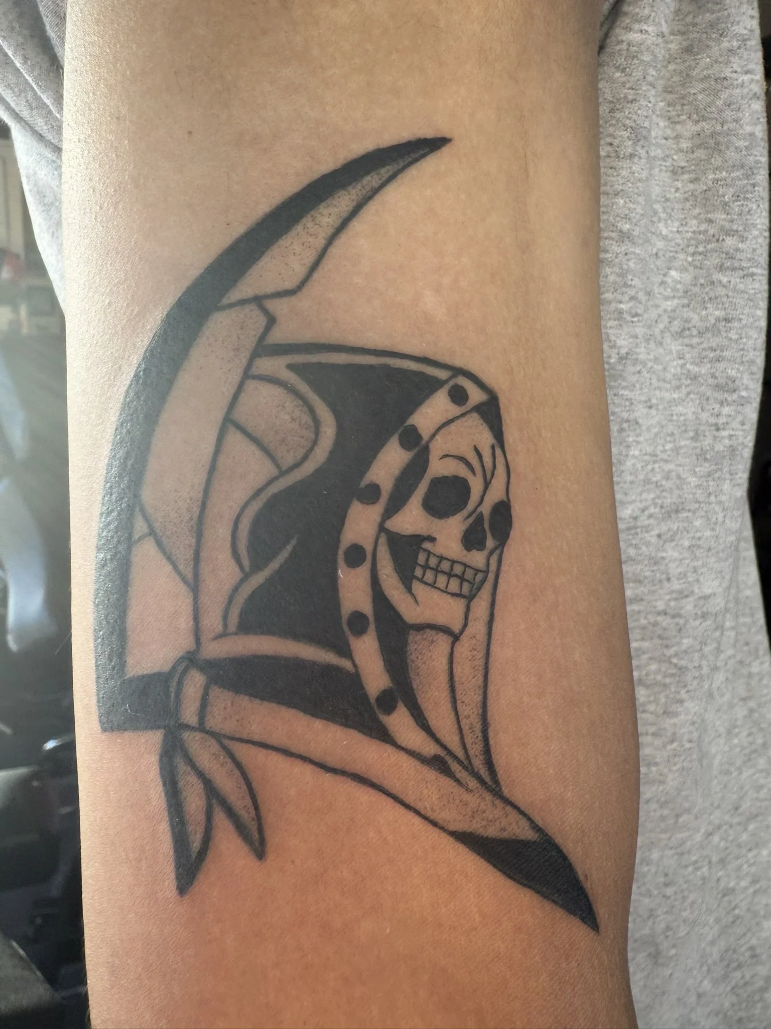 Tattoo of a skull integrated with a butterfly on a person's arm.