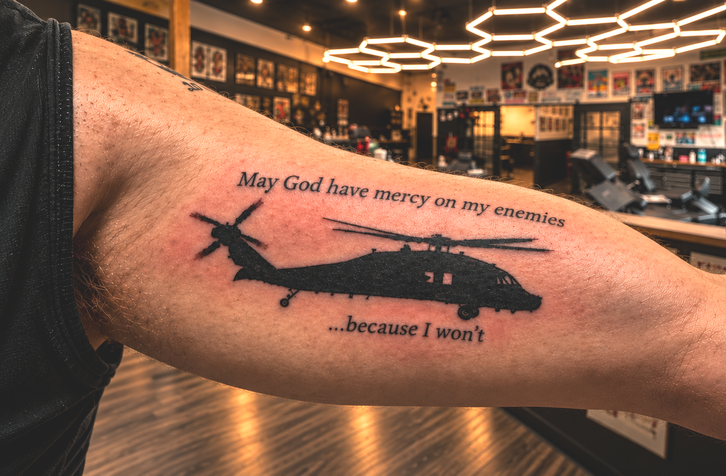 Tattoo of a helicopter on a person's arm with the text "May God have mercy on my enemies ... because I won't" in a tattoo parlor.