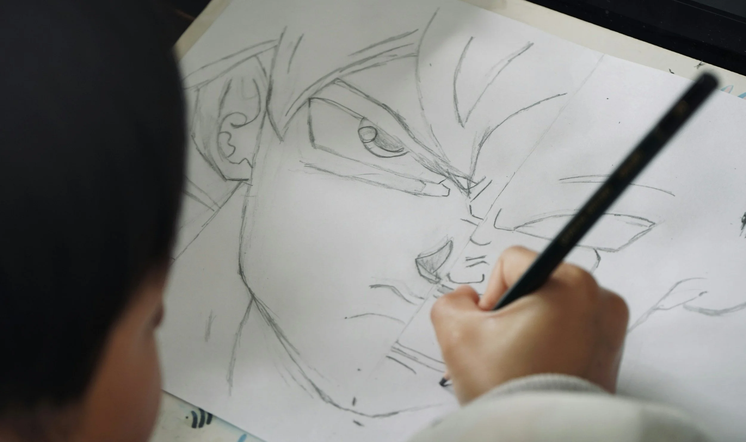 Processus de création chez Be More Prod, studio de direction artistique IA : dessin au crayon d'un personnage manga sur papier.