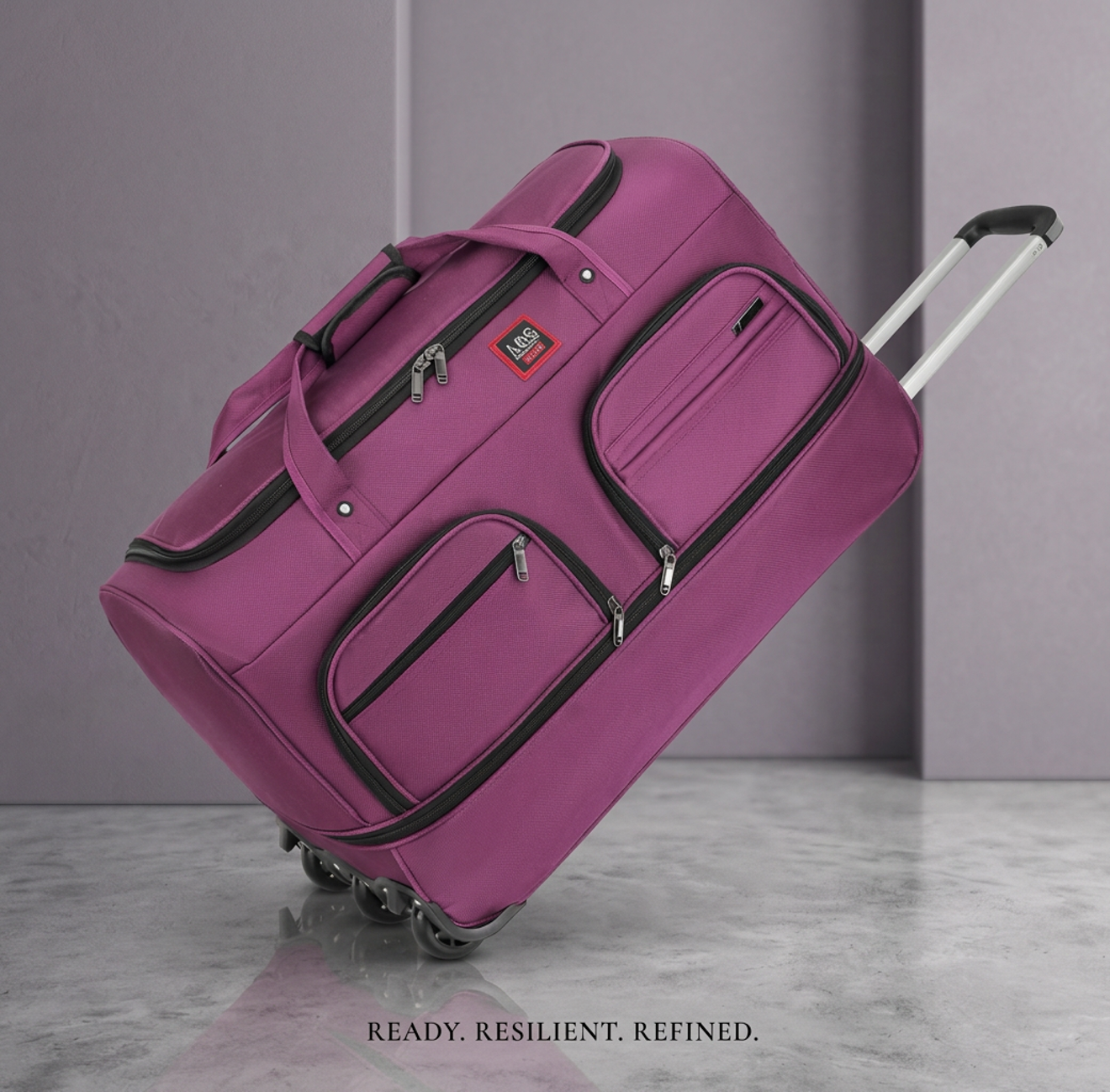 A purple wheel mounted duffle with multiple carrying handles and pockets on a grey marble floor.