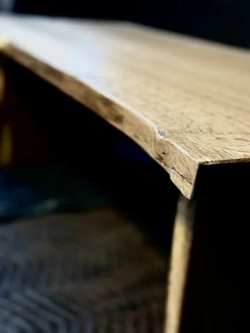 Close-up of a wooden shelf or piece of furniture with a natural finish.