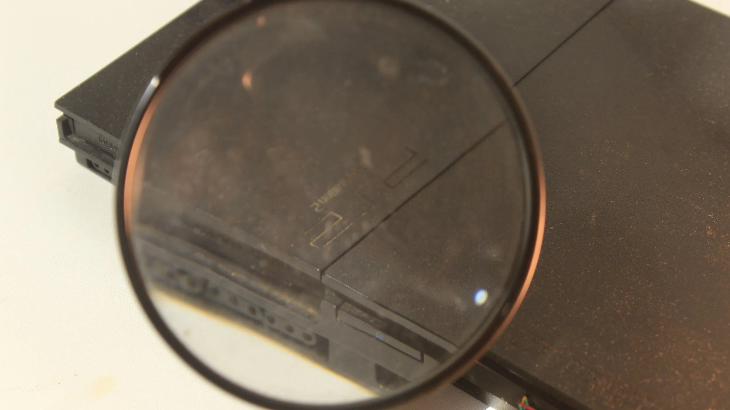 Close-up of a black electronic device with a round, reflective surface and a USB port visible on the side.