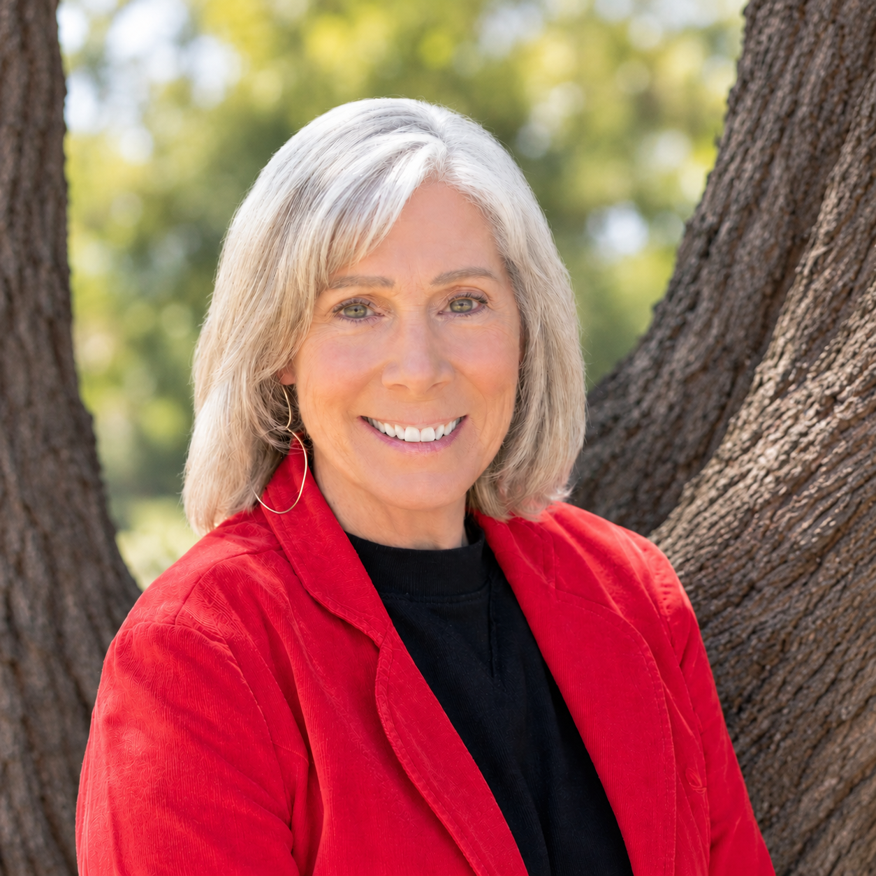 smiling woman in red blazer outdoors