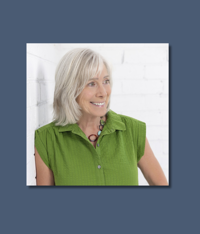 Woman in green blouse smilng, looking to the right