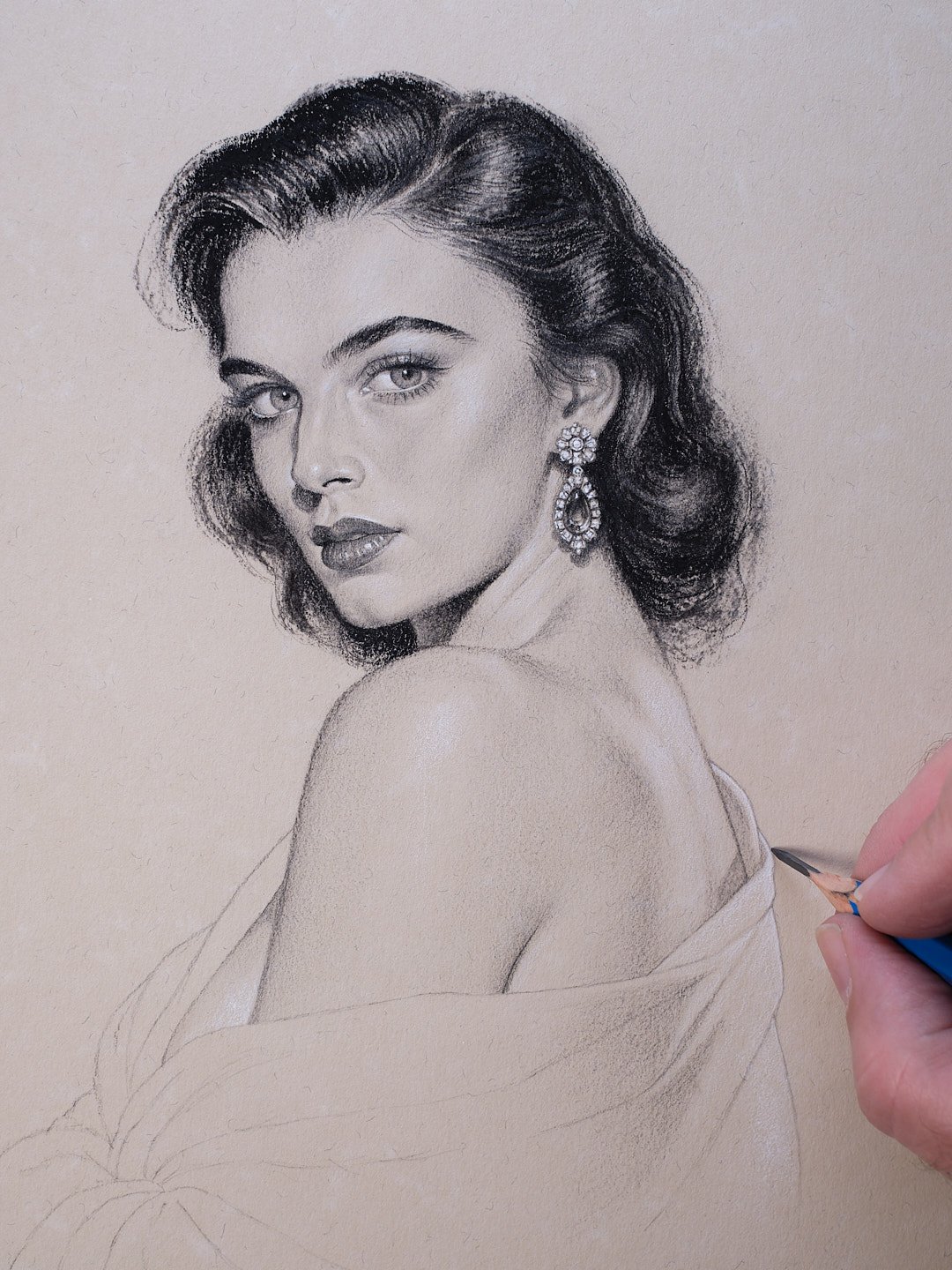 Artist sketching a glamorous vintage woman with wavy hair and dangling earrings using a blue pencil.
