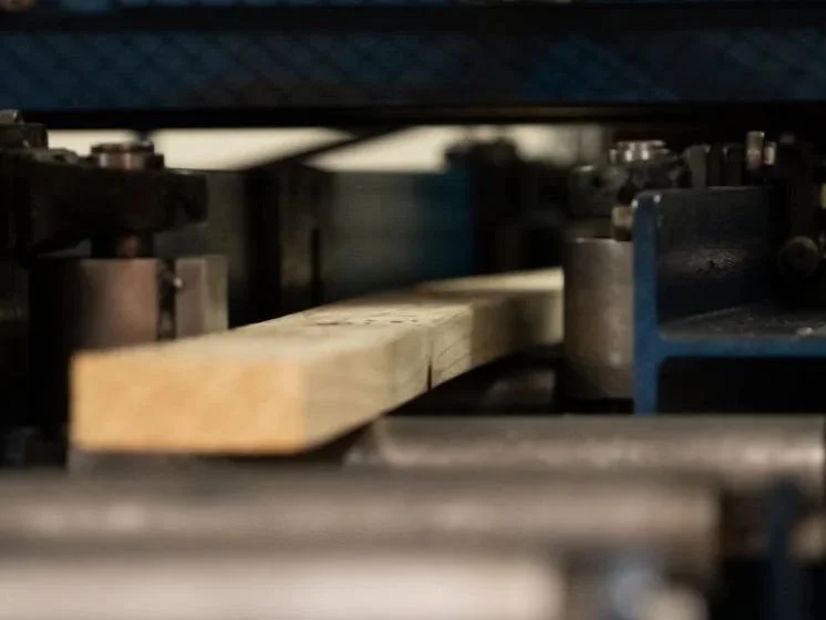 Close-up of a wood processing machine shaping a wooden plank.