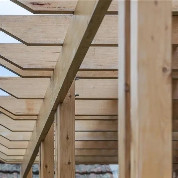 Close-up photo of wooden framing with horizontal and vertical beams, part of a building under construction.