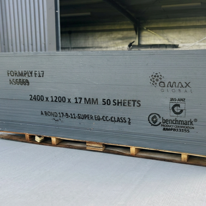 Stack of grey metal sheets on wooden pallets in a warehouse