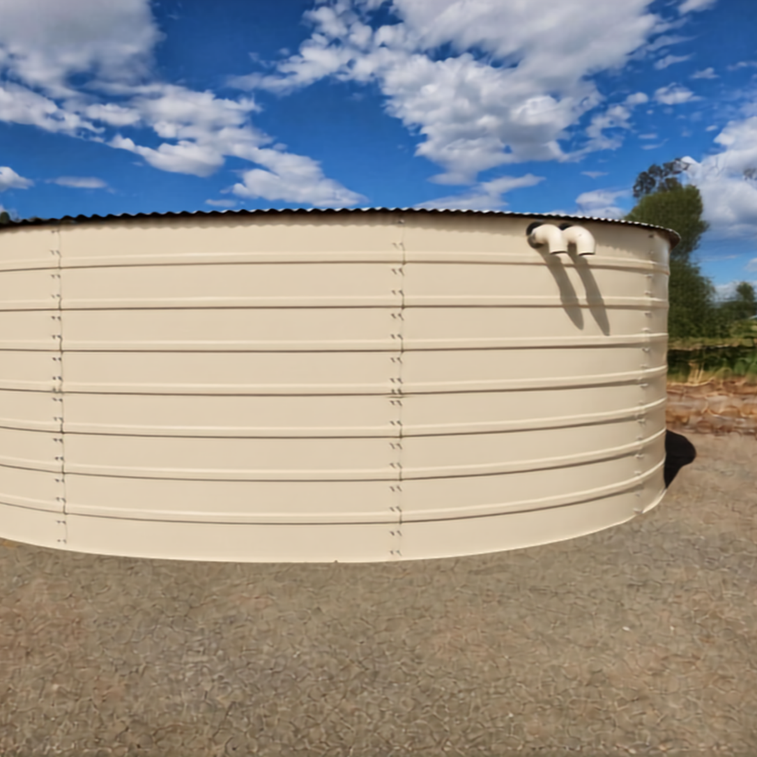 Large beige metal water tank outdoors on a gravel surface under a blue sky with scattered clouds, with some trees visible in the background.