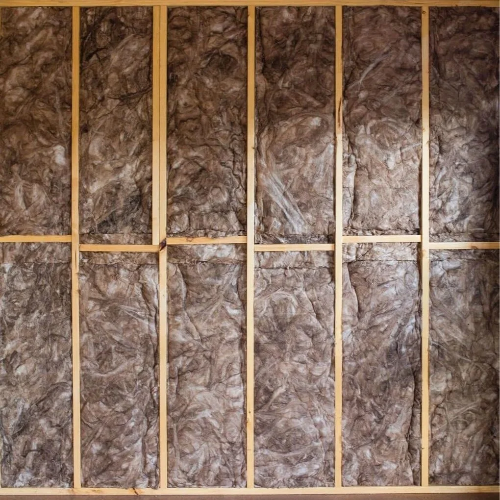 Insulation placed between wooden studs in a wall under construction.
