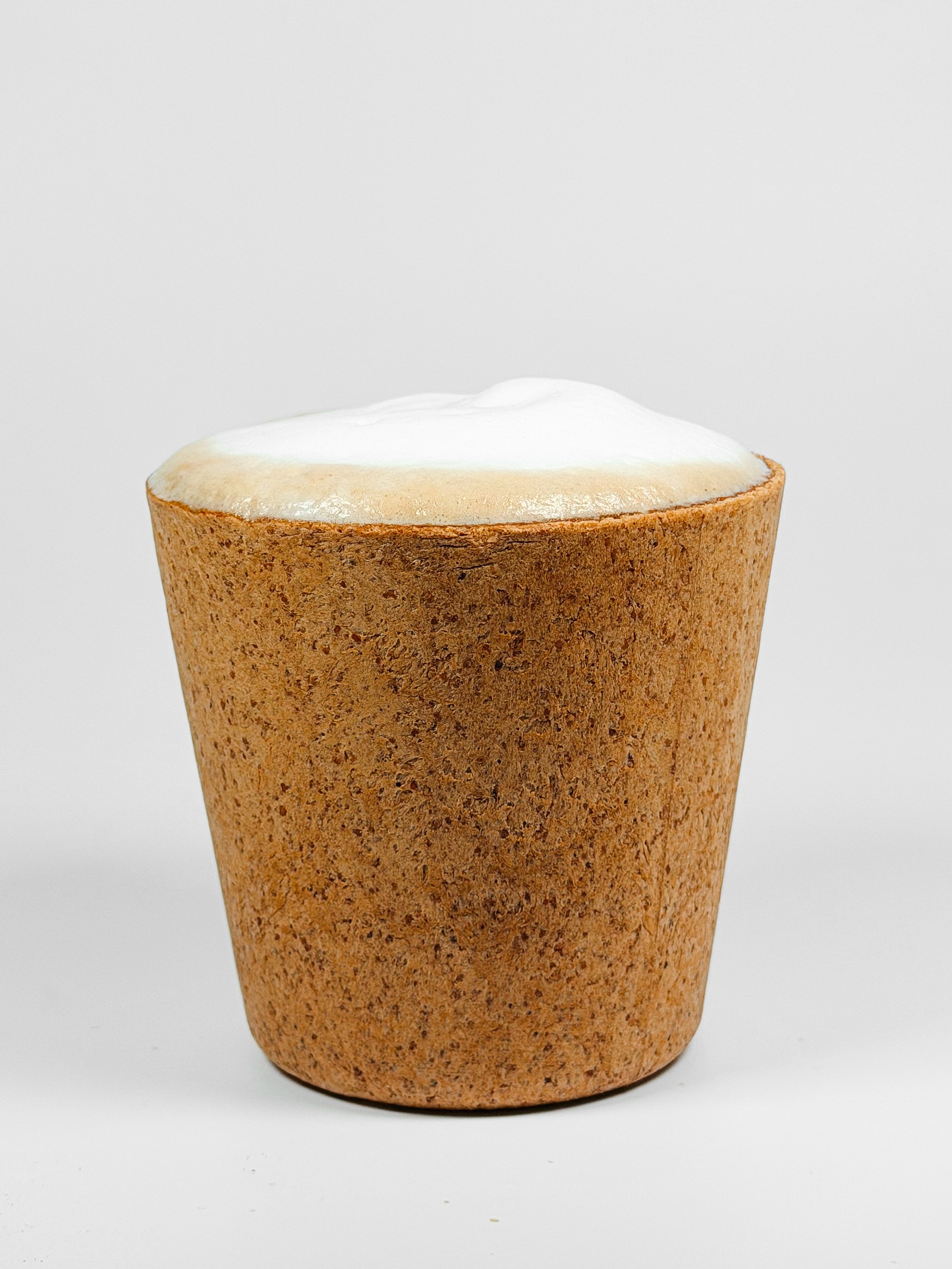 A close-up of a vanilla ice cream cone with a white background.