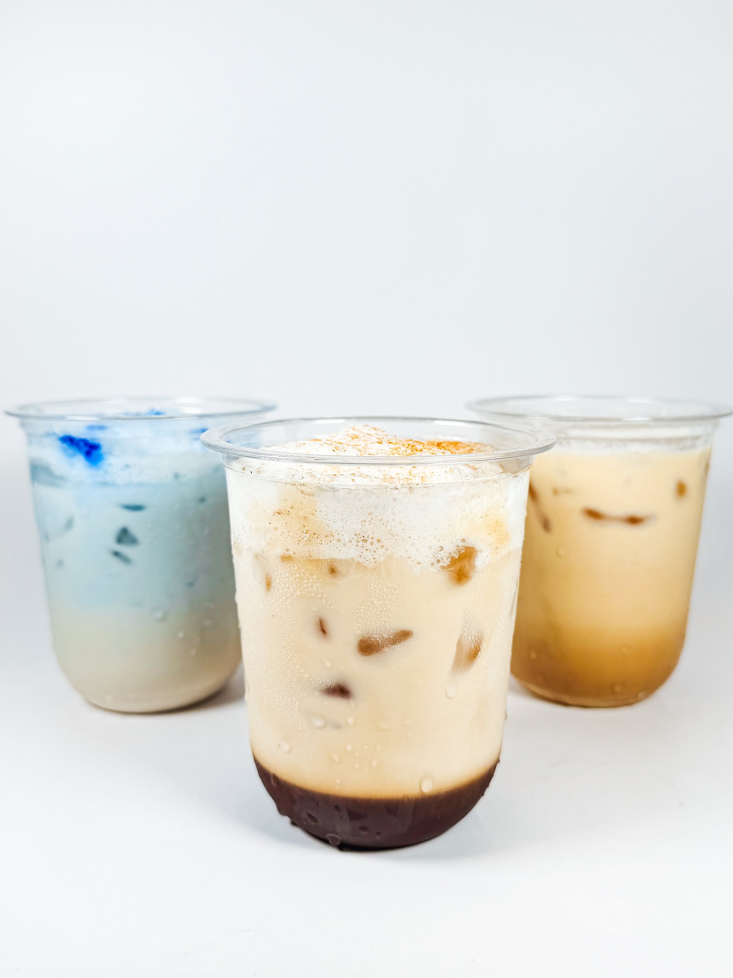 Three cups of ice cream with different flavors and toppings on a white background.