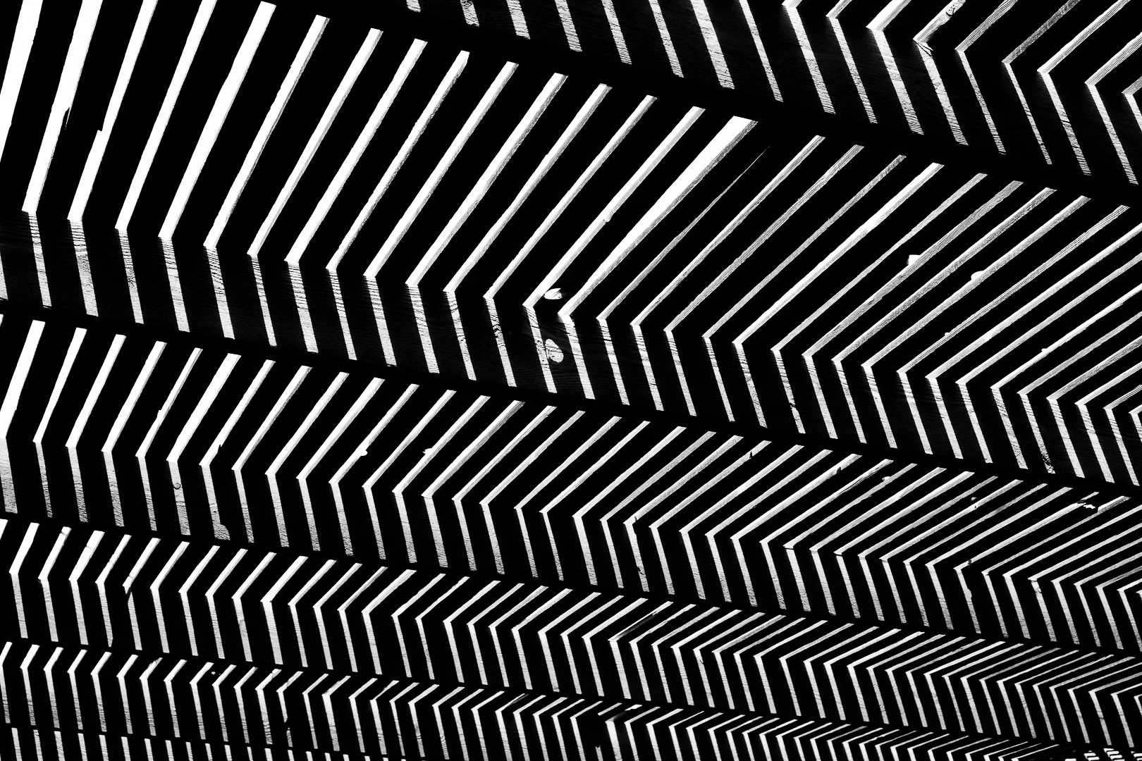 Black and white abstract pattern of geometric lines creating a 3D optical illusion effect.