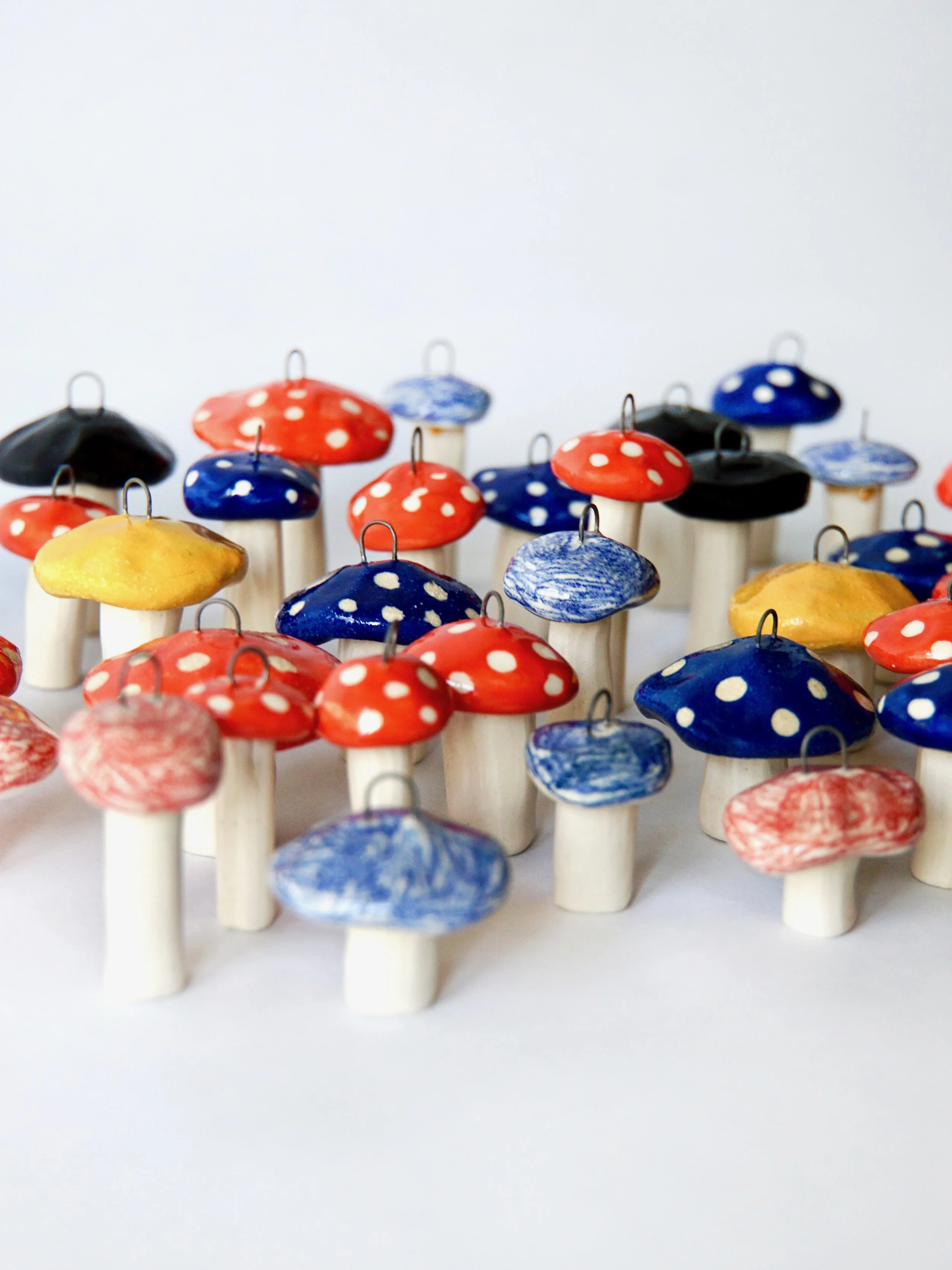 Colorful mushroom-shaped ornaments with polka-dot caps displayed on white stems
