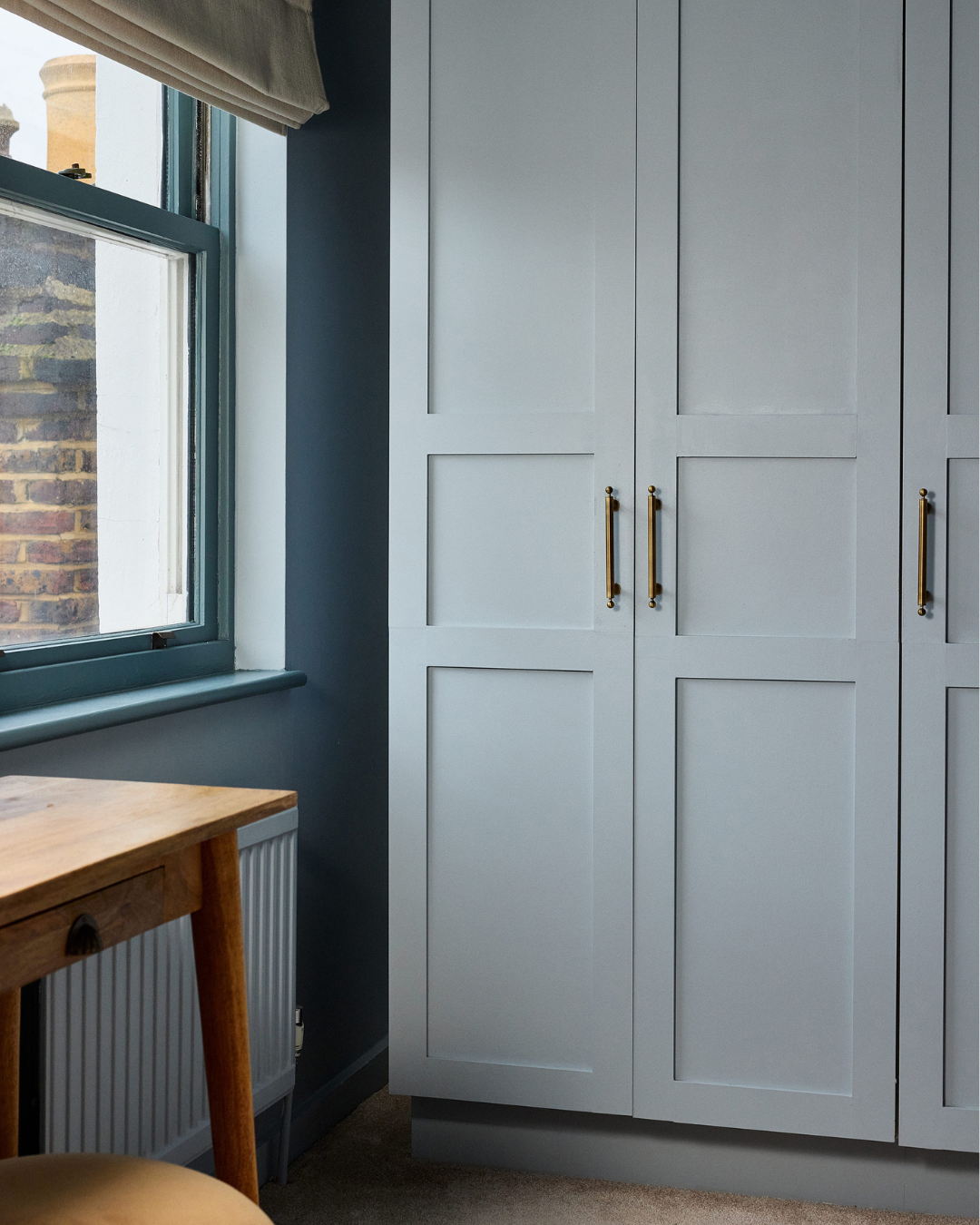 children room in light blue muted tones. with burgundy accents and wave patterns. side close angle wardrobe