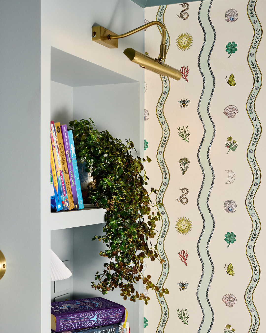 children room in light blue muted tones. with burgundy accents and wave patterns. close up shelves and wall light