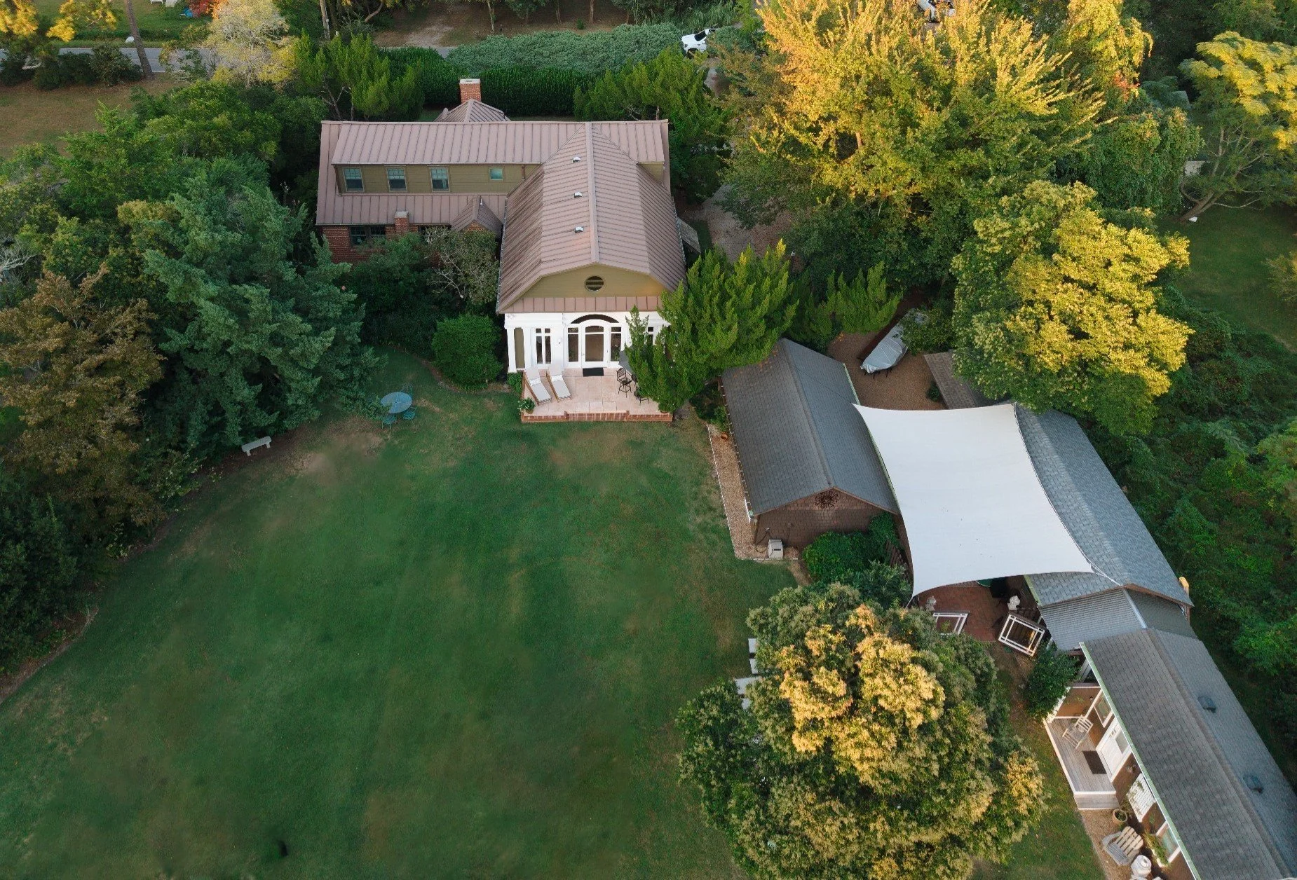 Aerial view of Bostwick’s Magnolia Manor showing the manor house, expansive lawn, mature trees, and covered courtyard. Katie Ludolph Photography