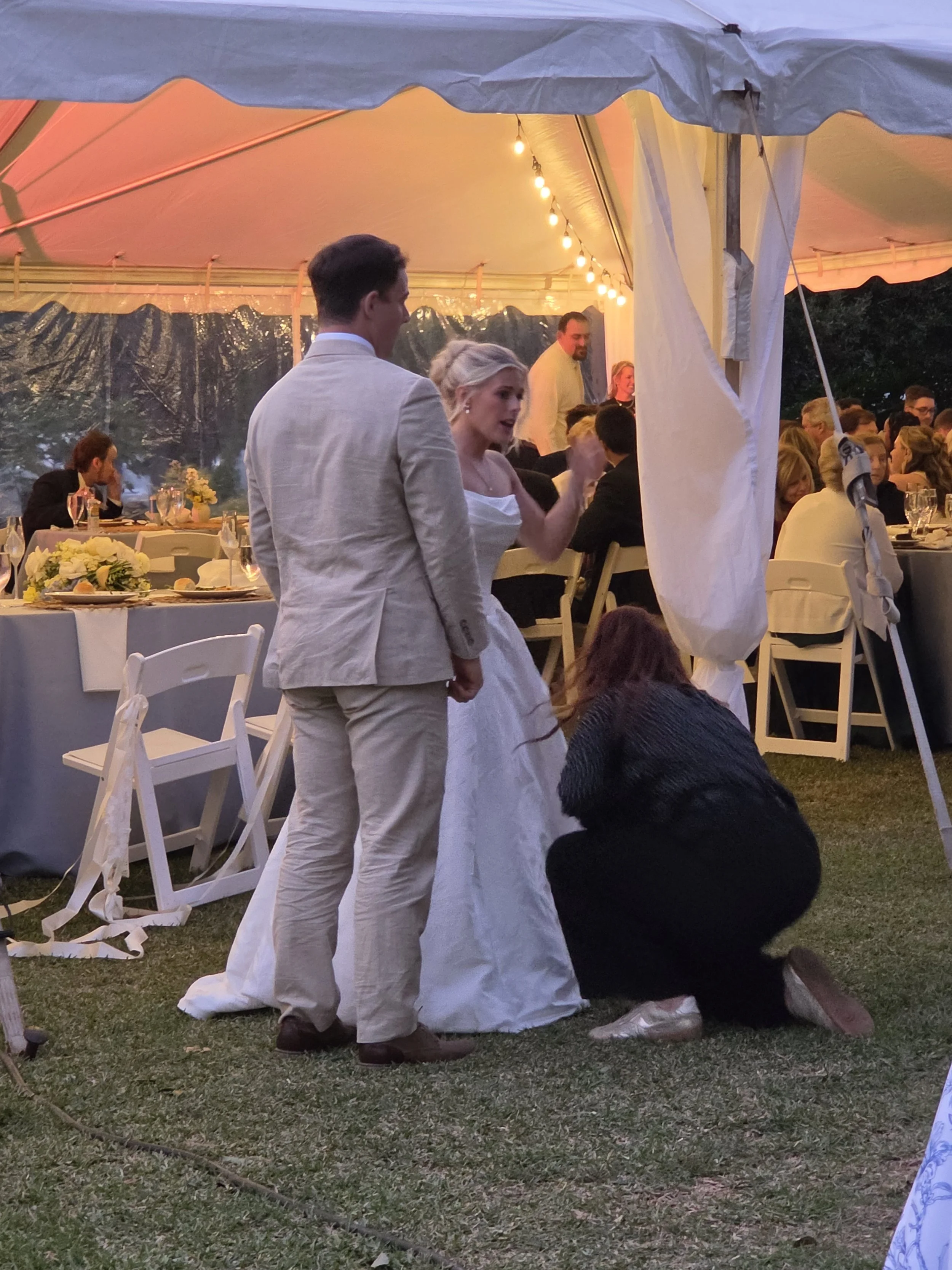 Wedding planner assisting bride with shoe change during reception