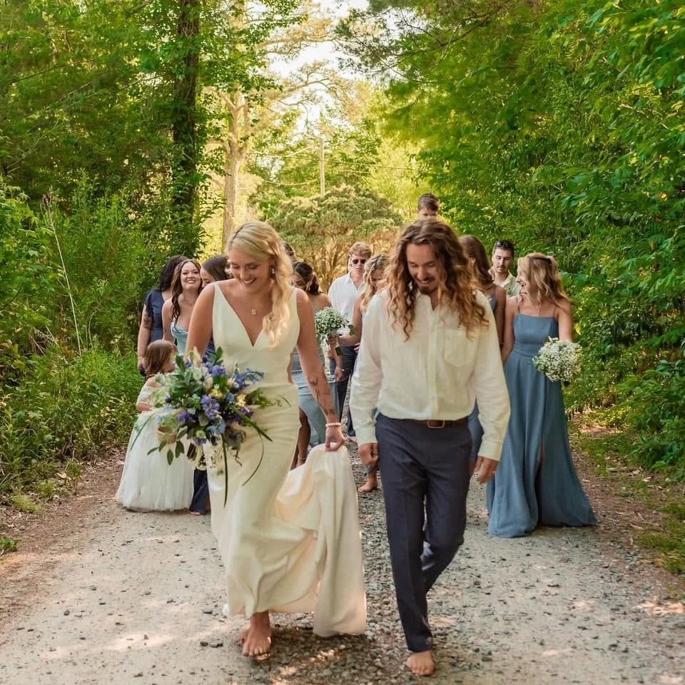 Beautiful young bride and groom walking barefoot through maritime woods.