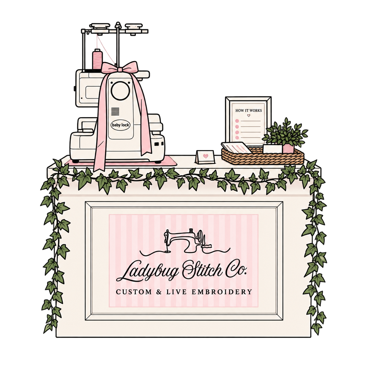 Decorative display for Ladybug Stitch Co. featuring a baby lock embroidery machine with a pink ribbon, framed instructions on how it works, a potted plant, and various embroidery supplies, all on a decorated table with ivy trim.
