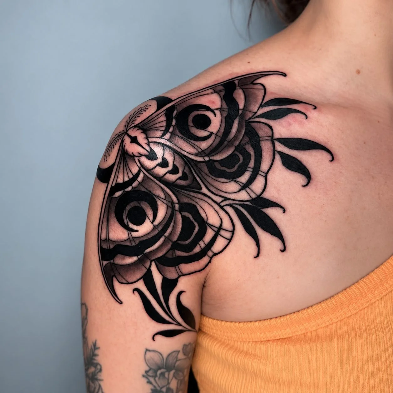 Black and gray neo-traditional moth shoulder tattoo by Adrian Aguirre in Miami, FL