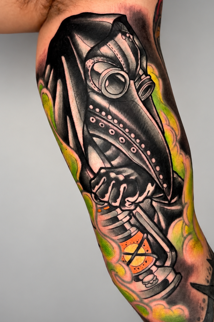 Plague doctor tattoo with toxic gas clouds on the upper arm, by Miami tattoo artist Adrian Aguirre.