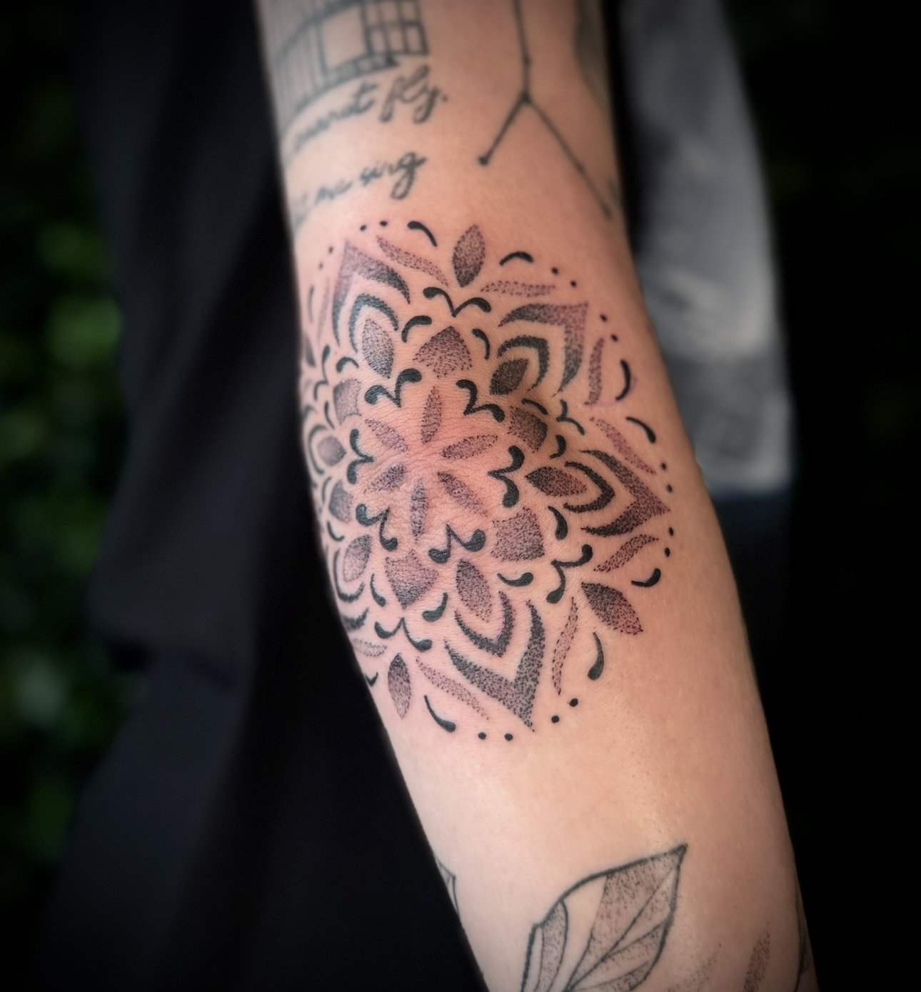 Tattoo of a detailed mandala pattern on a person's arm.
