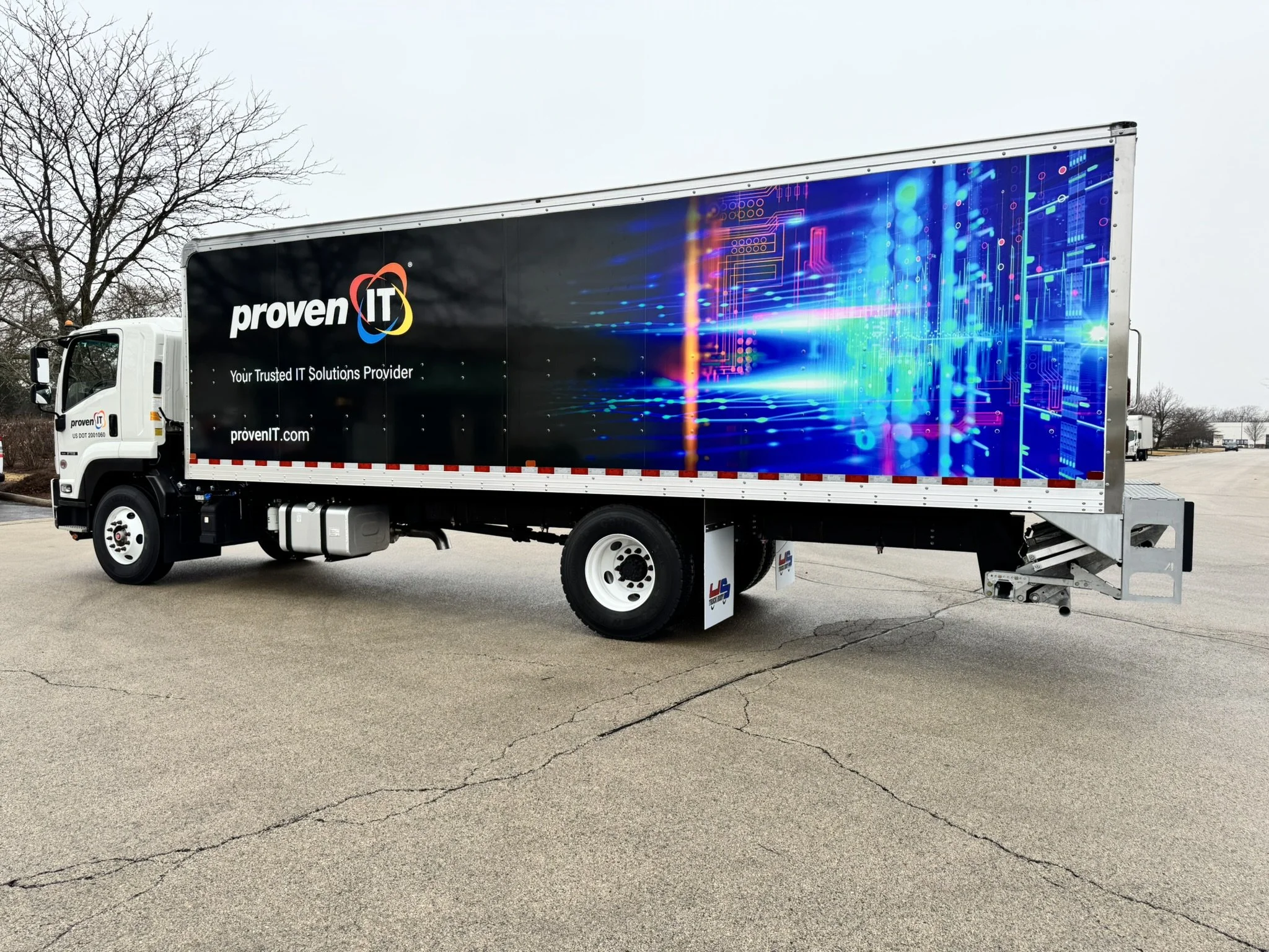 Large truck with a digital-themed advertisement for proven IT, a trusted IT solutions provider, with an abstract technological background on the side of the truck.