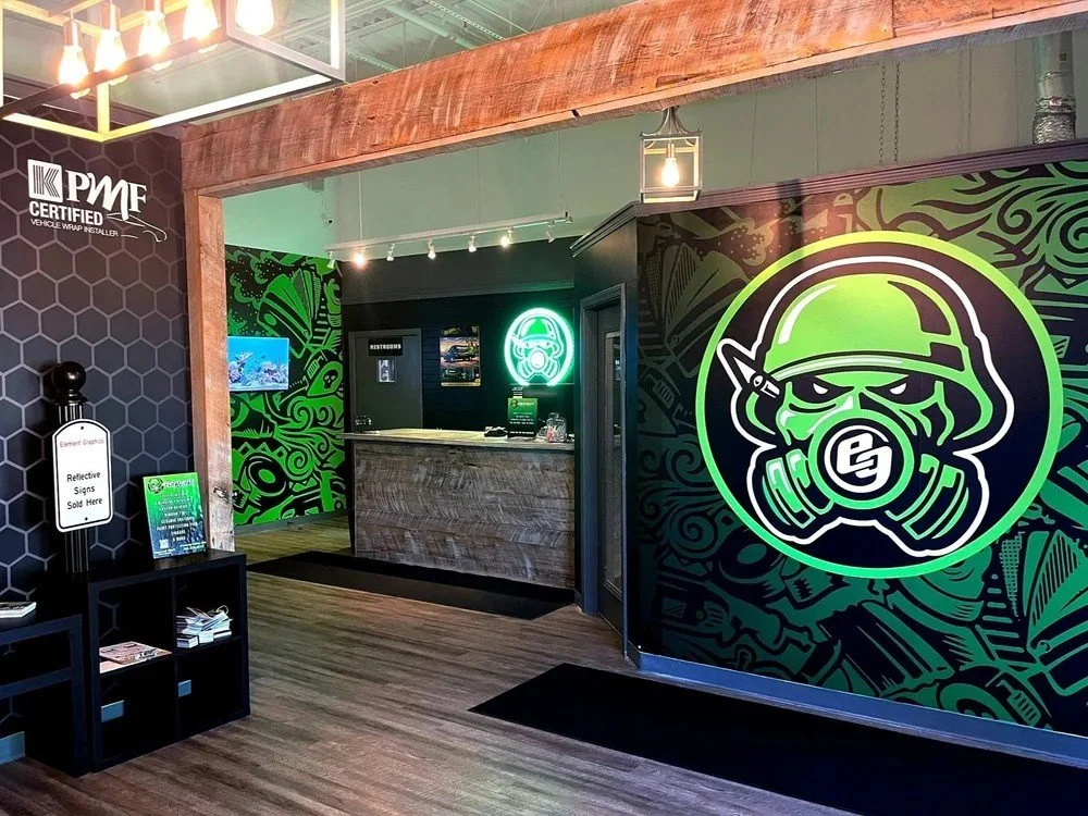 Element Graphics shop lobby in Mokena, IL with custom wall murals and neon logo sign