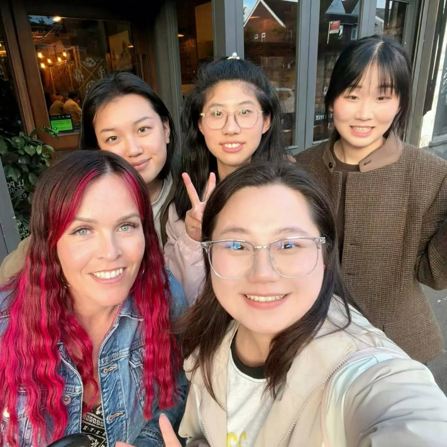 Sarah with a group of learners outside a café