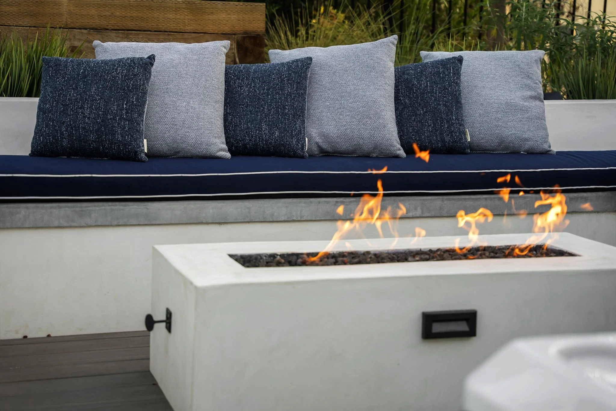 Custom linear fire pit with built-in outdoor seating by Rosewood Landscape