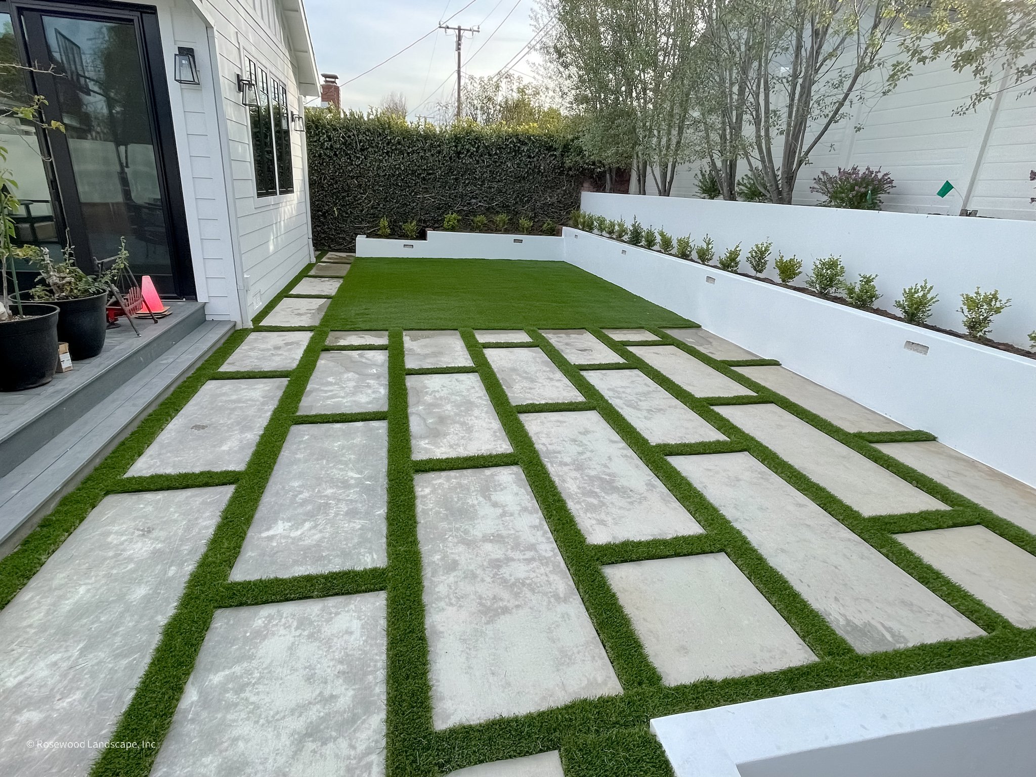 Modern concrete pavers with artificial turf and contemporary landscaping by Rosewood Landscape